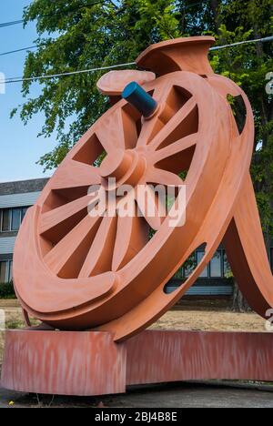 La sculpture de Fritz Church, la "Gateway", est la grande roue orange sur South Tacoma Way à Tacoma, Washington. Il repose sur deux pointes stylisées de chemin de fer. Banque D'Images