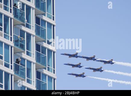 Jersey City, États-Unis. 28 avril 2020. Les spectateurs regardent depuis leur balcon les Blue Angels de la Marine américaine et les Thunderbirds de l'armée de l'air américaine voler en formation dans le New Jersey après avoir volé un World Trade Center et les gratte-ciel de Manhattan à New York le mardi 28 avril 2020. Une formation des Blue Angels de la Marine américaine et des Thunderbirds de l'armée de l'air américaine honorent les premiers intervenants sur les lignes de front de la pandémie de coronavirus en survolant New York, New Jersey et Pennsylvanie. Photo de John Angelillo/UPI crédit: UPI/Alay Live News Banque D'Images