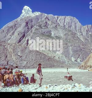 Pakistan, régions du nord des montagnes Karakoram. Un groupe européen de trekking partage la tâche commune de charger la boîte de Jola pour faciliter la traversée de la rivière Braldu à la tête de la gorge de Braldu. La Jola a depuis été remplacée par un pont suspendu pour faciliter et sécuriser la tâche Banque D'Images