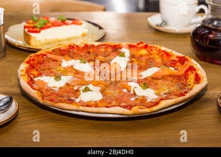 Pizza avec poisson et fromage sur une table en bois Banque D'Images