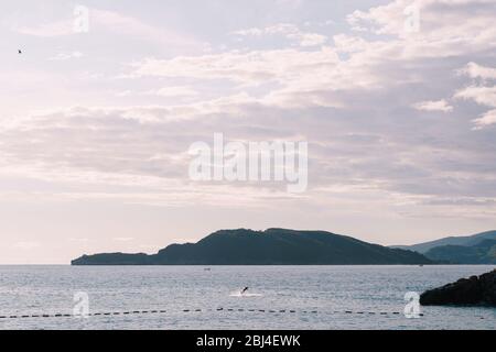 Le gars roule et tombe du surf électrique dans la mer Adriatique, Budva, Monténégro. Électro-surf à ailes avec moteur. Banque D'Images