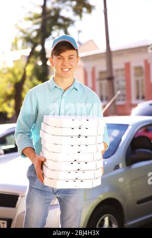 Livraison de pizza boîte de conservation avec pizza près de la voiture Banque D'Images