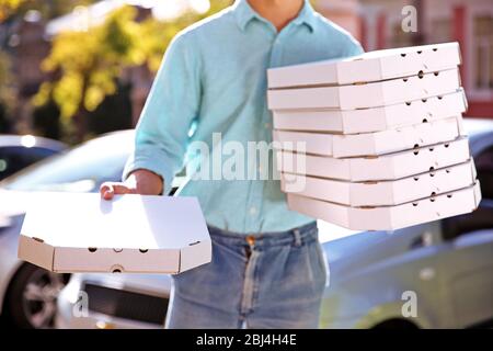 Livraison de pizza boîte de conservation avec pizza près de la voiture Banque D'Images