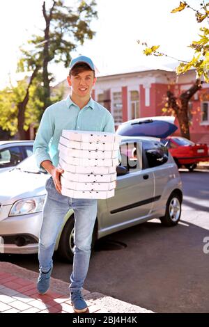 Livraison de pizza boîte de conservation avec pizza près de la voiture Banque D'Images