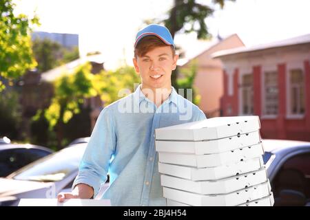 Livraison de pizza boîte de conservation avec pizza près de la voiture Banque D'Images