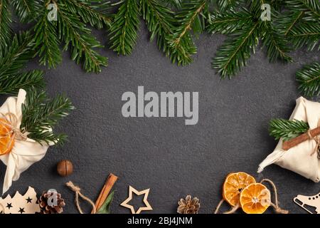 Concept de noël zéro déchet. Emballé dans des cadeaux et des décorations en tissu naturel à partir de matériaux naturels sur une table noire, vue sur le dessus, espace de copie. Banque D'Images