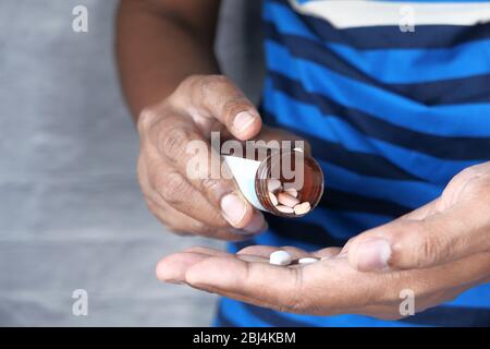 Verser les pilules de la bouteille blanche dans la paume Banque D'Images
