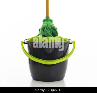 Nettoyage de la mop sur un seau de couleur noire verte isolée sur fond blanc, nettoyage domestique Banque D'Images
