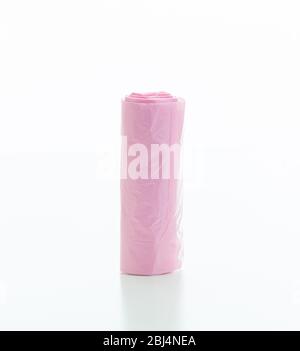 Sacs poubelle rouleau couleur rose isolé sur fond blanc, nettoyage domestique de ménage, concept de sacs à ordures Banque D'Images