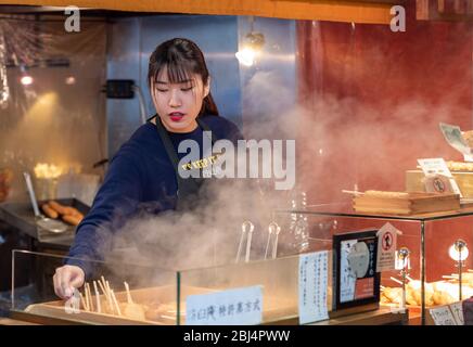 Un vendeur au marché Nishiki également connu sous le nom de cuisine Kyotos vendant des aliments Banque D'Images