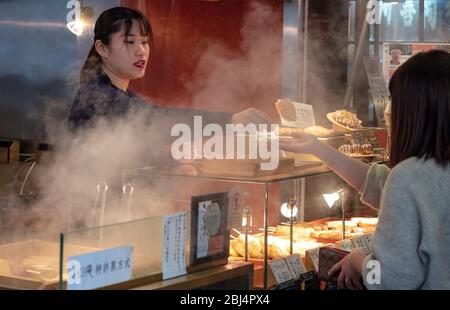 Un vendeur au marché Nishiki également connu sous le nom de cuisine Kyotos vendant des aliments Banque D'Images