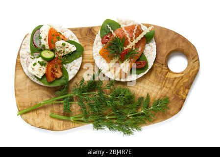 haalez le sandwich au gâteau de riz isolé sur fond blanc. Gâteaux de riz au basilic, tomates, fromage et truite rouge ou poisson de saumon Banque D'Images