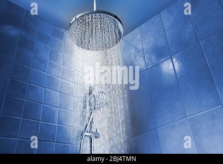 Faible angle d'eau de marche de la tête de douche dans une douche de couleur fraîche dans la salle de bains Banque D'Images