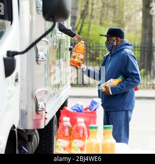 Bridgeport, CT, États-Unis. 28 avril 2020. La nourriture est distribuée à Bridgeport, dans le Connecticut par Hang Time, une organisation de base qui soutient les récemment incarcérés, avec de la nourriture, la bourse, l'aide pour obtenir un emploi, et d'autres services de soutien. La nourriture est offerte avec l'aide du Centre pour l'équité alimentaire et le développement économique du Conseil des Églises du Grand Bridgeport et de la Harvard Pilgrim Healthcare Foundation. Crédit: Stan Godlewski/ZUMA Wire/Alay Live News Banque D'Images