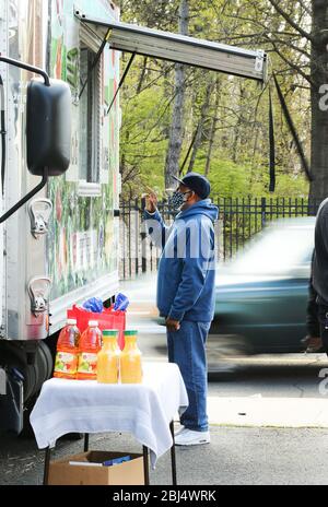 Bridgeport, CT, États-Unis. 28 avril 2020. Un client recevant des aliments distribués à Bridgeport, dans le Connecticut par Hang Time, une organisation de base soutenant les récemment incarcérés, avec de la nourriture, la bourse, l'aide pour obtenir un emploi, et d'autres services de soutien. La nourriture est offerte avec l'aide du Centre pour l'équité alimentaire et le développement économique du Conseil des Églises du Grand Bridgeport et de la Harvard Pilgrim Healthcare Foundation. Crédit: Stan Godlewski/ZUMA Wire/Alay Live News Banque D'Images