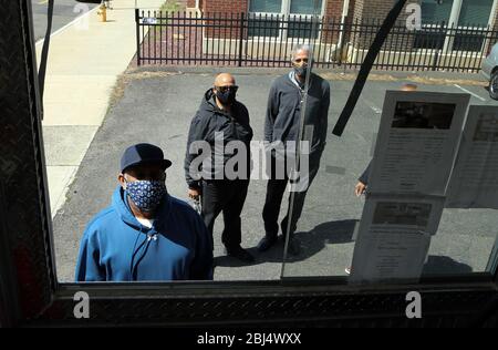 Bridgeport, CT, États-Unis. 28 avril 2020. Les clients attendent que la nourriture soit distribuée à Bridgeport, dans le Connecticut par Hang Time, une organisation de base qui soutient les récemment incarcérés, avec de la nourriture, de la bourse, de l'aide pour obtenir un emploi, et d'autres services de soutien. La nourriture est offerte avec l'aide du Centre pour l'équité alimentaire et le développement économique du Conseil des Églises du Grand Bridgeport et de la Harvard Pilgrim Healthcare Foundation. Crédit: Stan Godlewski/ZUMA Wire/Alay Live News Banque D'Images