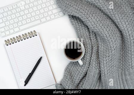Plat de travail confortable de l'écriture avec le café chaud du sweat, ordinateur portable et carnet de notes. Travail à la maison. Écriture. Concept chaud par temps froid. Banque D'Images