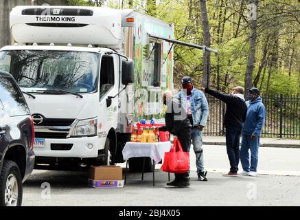 Bridgeport, CT, États-Unis. 28 avril 2020. La nourriture est distribuée à Bridgeport, dans le Connecticut par Hang Time, une organisation de base qui soutient les récemment incarcérés, avec de la nourriture, la bourse, l'aide pour obtenir un emploi, et d'autres services de soutien. La nourriture est offerte avec l'aide du Centre pour l'équité alimentaire et le développement économique du Conseil des Églises du Grand Bridgeport et de la Harvard Pilgrim Healthcare Foundation. Crédit: Stan Godlewski/ZUMA Wire/Alay Live News Banque D'Images