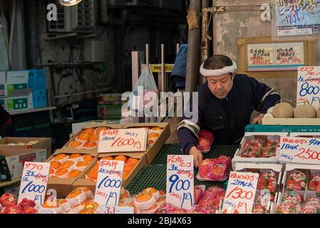 Vendeur au marché Ameyoko, en organisant la vente de fruits et légumes. Tokyo, Japon Banque D'Images