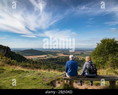 Un couple âgé s'est assis sur un banc en bois qui regarda la vallée de York de Sutton Bank. Banque D'Images
