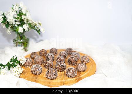 Morsures énergétiques de beurre d'arachide aux protéines à la mode ou boules énergétiques. Truffes au chocolat cru maison avec noix de coco en flocons. Banque D'Images