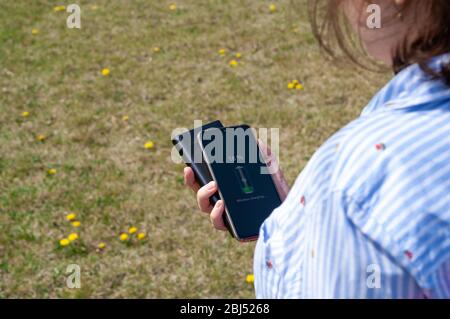 Une fille charge smartphone sans câble de la banque d'alimentation à induction dans le parc. Concept de technologie moderne. Mise au point sélective Banque D'Images