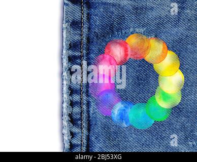 Jean denim fond avec cadre rond en blobs multicolores arc-en-ciel. Cadre aquarelle avec des gouttes colorées arc-en-ciel sur la texture du Jean Banque D'Images