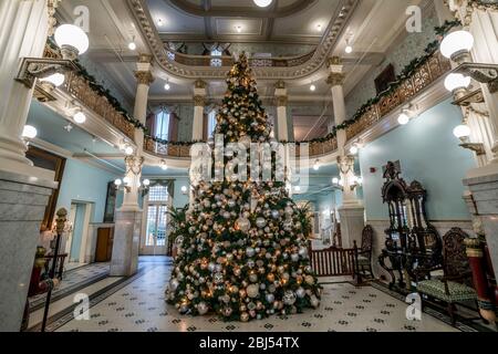 Un arbre de Noël apporte une chaleur festive à l'obby d'un hôtel historique de San Antonio au Texas. Banque D'Images