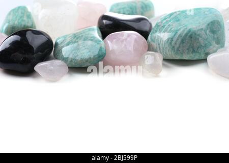 Pile de pierres : quartz rose, azonite, onyx noir et cristal de roche isolé sur fond blanc Banque D'Images