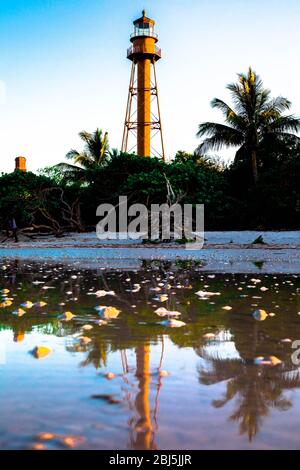 Le phare de Sanibel Island se reflète dans l'océan au coucher du soleil Banque D'Images