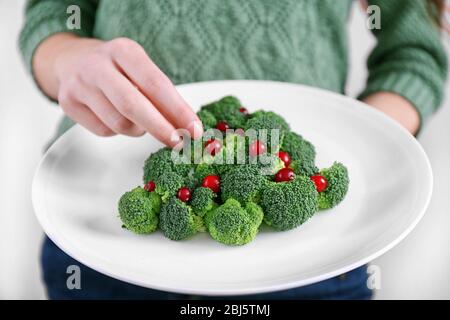 Femme tenant une assiette avec sapin de Noël fait de brocoli Banque D'Images