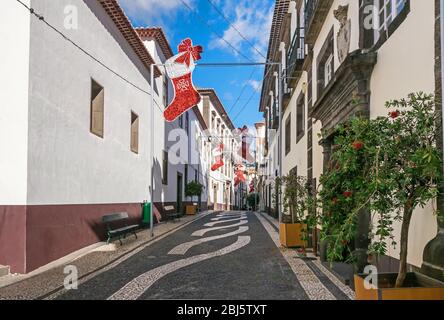 Funchal, Portugal - 10 novembre 2019: Centre historique et une des rues étroites avec décoration de Noël et pavé typique portugais avec d Banque D'Images