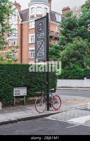 Londres/UK-30/07/18 : vélo à roues rouges enchaîné au pilier dans une rue de Londres. Les vélos offrent un important mode de transport dans de nombreux en développement c Banque D'Images