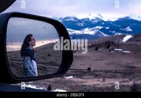 Jeune femme regardant le coucher du soleil dans les montagnes reflétées miroir Banque D'Images