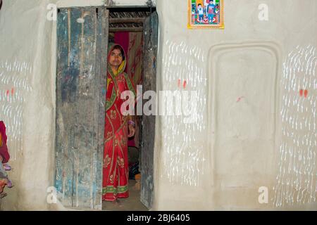 Femme rurale debout à la porte de maison dans le village, Inde Banque D'Images