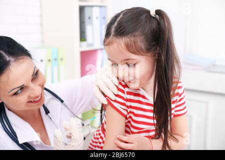 Médecin donnant une injection d'enfant dans le bureau Banque D'Images
