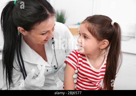 Médecin donnant une injection d'enfant dans le bureau Banque D'Images