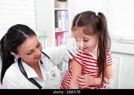 Médecin donnant une injection d'enfant dans le bureau Banque D'Images