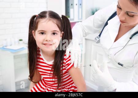 Médecin donnant une injection d'enfant dans le bureau Banque D'Images