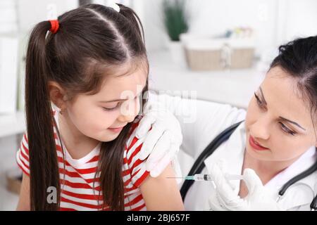Médecin donnant une injection d'enfant dans le bureau Banque D'Images