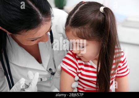Médecin donnant une injection d'enfant dans le bureau Banque D'Images