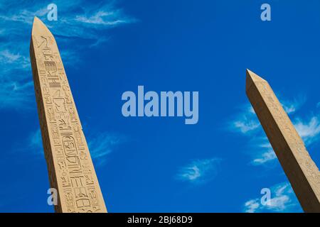 Deux Obelisks au temple de Karnak à Louxor avec des sculptures hiéroglyphiques sur fond bleu ciel Banque D'Images