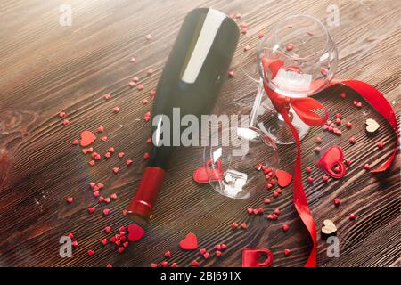 Bouteille de vin et verres avec coeurs faits main sur fond en bois, gros plan Banque D'Images