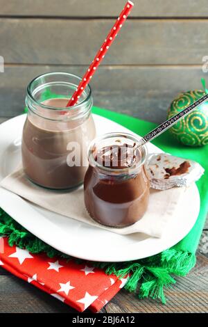 Dessert au chocolat dans un petit bocaux en verre et cocktail au lait au chocolat sur fond de bois Banque D'Images