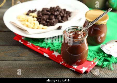 Dessert au chocolat dans de petits pots en verre et des morels sur plaque, sur fond en bois Banque D'Images