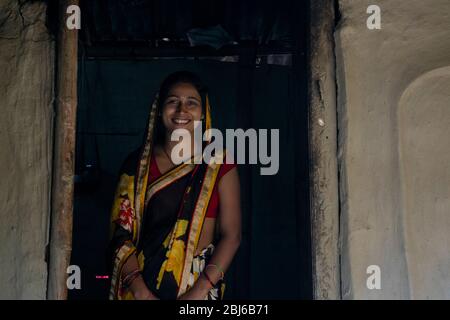 Femme rurale debout à la porte de la maison dans le village, Inde Banque D'Images