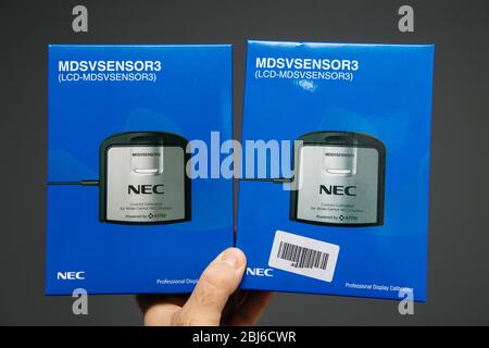 Paris, France - 27 février 2019 : main mâle tenant deux écrans Nec calibrés par le client pour les écrans large-Gamut Nec équipés d'un calibrateur X-rite pour des couleurs précises sur les écrans Spectraview et Reference Banque D'Images