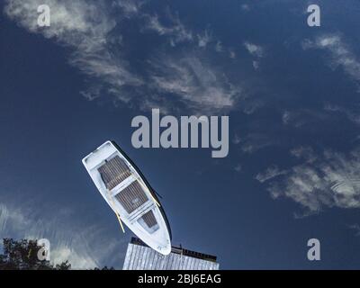 Vue aérienne sur la jetée avec un bateau attaché avec nuages réfléchissants dans l'eau, sur une petite île verte Banque D'Images