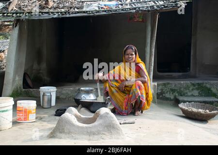Rural Indian Woman cuisine de nourriture dans la cuisine à l'aide de poêle à bois Banque D'Images