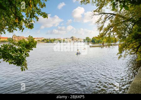 Les touristes et les Tchèques locaux se rendent en kayak près des chutes sur la Vltava à Prague, en République tchèque, l'après-midi d'été. Prise de Kampa Island. Banque D'Images